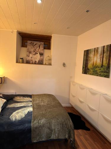 1 dormitorio con 1 cama y una pintura en la pared en L 'étape, en Soultz-Haut-Rhin