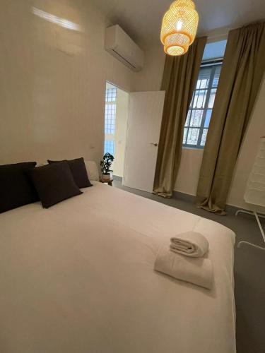 1 dormitorio con 1 cama blanca grande con sombrero en New Piso Centrico para 7pax a 2 min andando de Gran Via, en Madrid