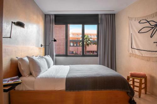 - une chambre avec un grand lit et une fenêtre dans l'établissement Appartements Brummell Marrakech, à Marrakech