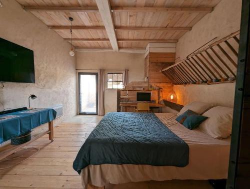 - une chambre avec un grand lit et un bureau dans l'établissement Logement - Studio indépendant à Pérouges, à Pérouges