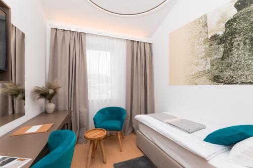 a hotel room with a bed and a desk and chairs at Hotel Sveta Ana in Donji Humac