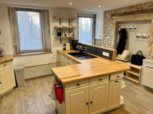 une cuisine avec un comptoir en bois dans une pièce dans l'établissement Coquette maison de pêcheur, à Ouistreham