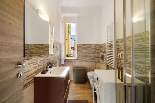 Un baño con lavabo y lavadora. en Casa Febe, en Levanto