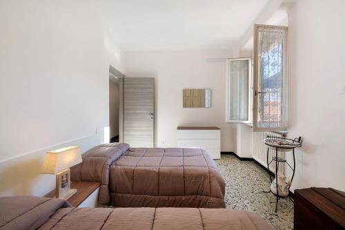 Un dormitorio con dos camas y una mesa dentro. en Casa Febe, en Levanto