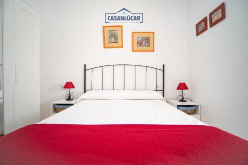 a bedroom with a large bed with a red blanket at Apartamento mi Gitana in La Jara