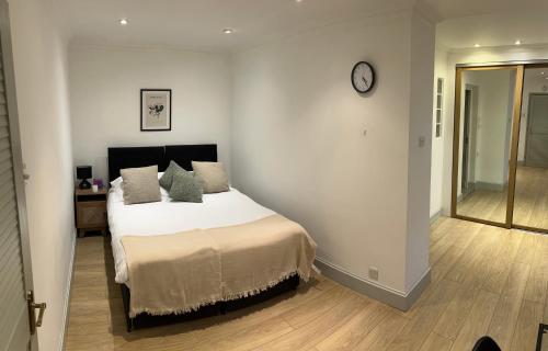a bedroom with a bed with a clock on the wall at 7a in London