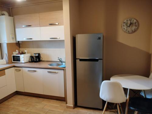 una cocina con nevera de acero inoxidable y armarios blancos en Central Apartment in Mihai Viteazu Square en Cluj-Napoca