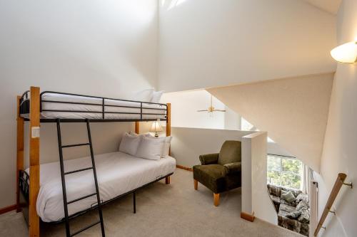 a bedroom with a bunk bed and a chair at Bright 2 bedroom and loft suite in the Wildwood Lodge in Whistler