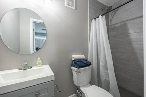 a bathroom with a toilet and a sink and a mirror at NEW Updated 2BR Apartment in DC in Washington