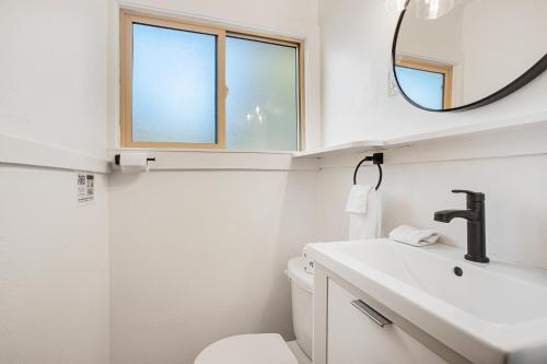 Un baño blanco con lavabo y espejo. en Mount Constance, Room 10 at Mount Walker Inn, en Quilcene