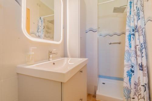 y baño blanco con lavabo y ducha. en Capo d'Arco la Terrazza - Goelba en Capo D'Arco