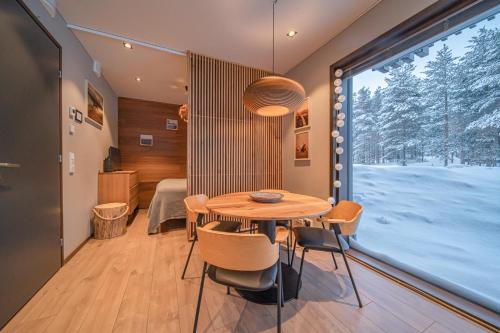 a dining room with a table and a large window at Levi Platinum Aurora in Levi