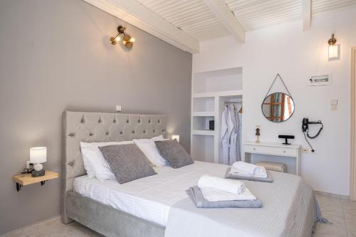 a white bedroom with a large bed with towels on it at Southbank seafront apartments in Katelios