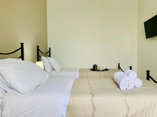 two beds in a room with white sheets and towels at Tre Balconi - Casa Vacanza Salento in Carmiano