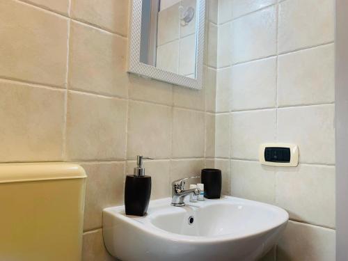 a bathroom with a sink and a mirror at Tre Balconi - Casa Vacanza Salento in Carmiano