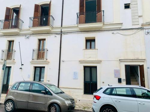 two cars parked in front of a building at Tre Balconi - Casa Vacanza Salento in Carmiano