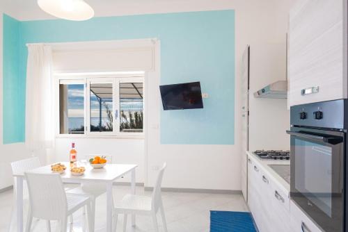 a white kitchen with a white table and chairs at Villa Monteduro - Leuca in Leuca
