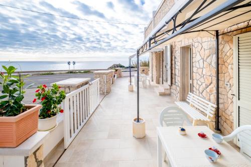 a balcony with tables and a view of the ocean at Villa Monteduro - Leuca in Leuca