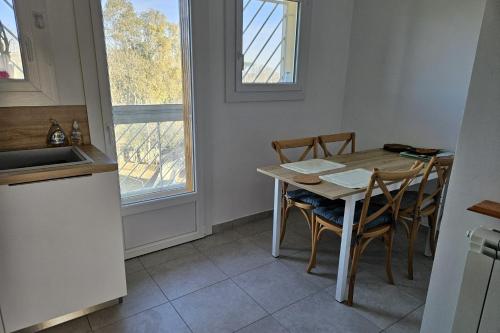 une cuisine avec une table et des chaises et une fenêtre dans l'établissement Bright apartment - near the beach, au Pradet
