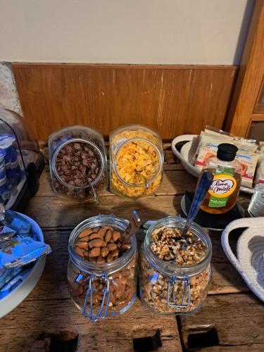 a table with four jars of nuts and other food at Albergo Baschera in Fagagna
