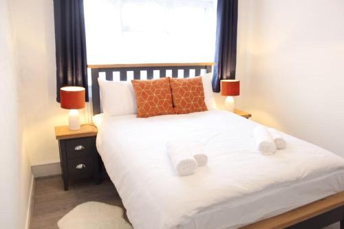 Stunning 3 bedrooms flat at Orchard House في هارلو: غرفة نوم بسرير ابيض ومصباحين