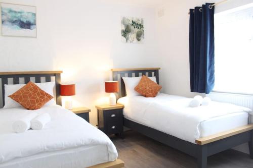 dos camas sentadas una al lado de la otra en un dormitorio en Stunning 3 bedrooms flat at Orchard House en Harlow