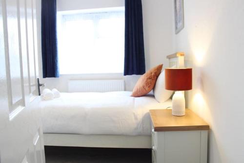 a bedroom with a white bed with a window at Stunning 3 bedroom apartment in Harlow, Essex in Harlow