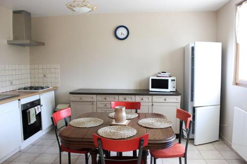 eine Küche mit einem Tisch und Stühlen sowie einem Kühlschrank in der Unterkunft Holiday home at the edge of La Seine near Giverny in Moisson