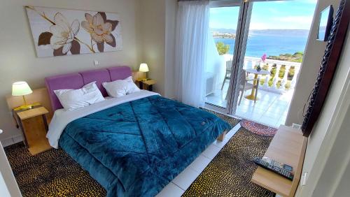 a bedroom with a bed with a view of the ocean at Dea Del Mare complex in front of the sea. in Sounio