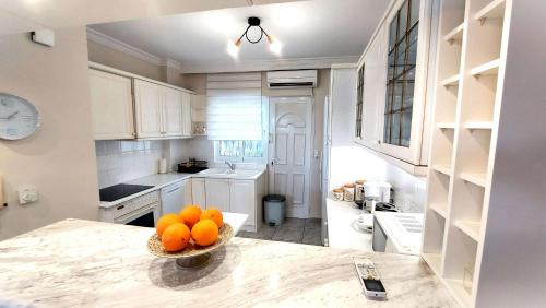 a kitchen with a bowl of oranges on a counter at Dea Del Mare complex in front of the sea. in Sounio