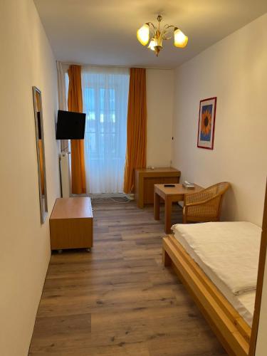 a bedroom with a bed and a table and a desk at City Hotel Post 21 in Braunau am Inn