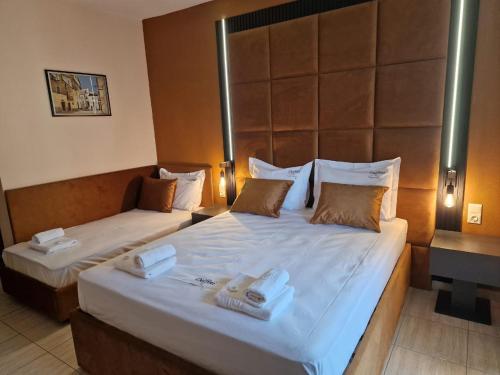een hotelkamer met 2 bedden en handdoeken erop bij Pension Delfini in Asprovalta