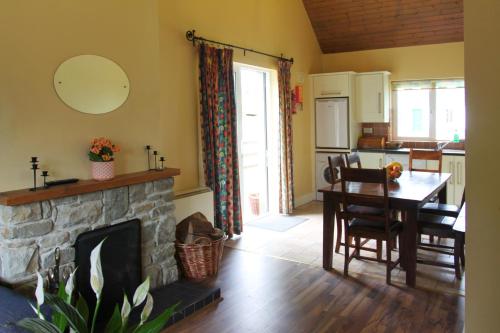a living room with a table and a fireplace at Leitrim Quay - Riverside Cottage 3 in Leitrim