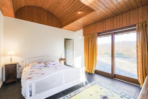 a bedroom with a bed and a large window at Villa Architecte des années 70 in Vif