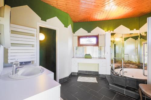 a bathroom with a large tub and a sink at Villa Architecte des années 70 in Vif