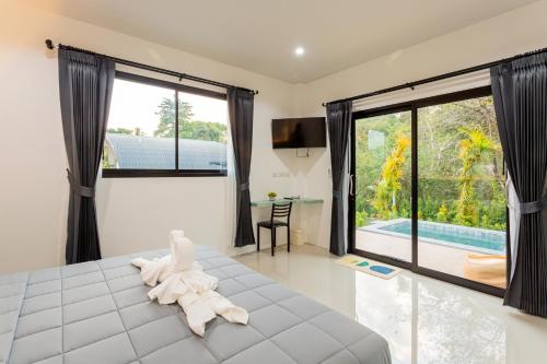 a bedroom with a bed and a large window at Villa loved beach 3 in Ao Nam Mao