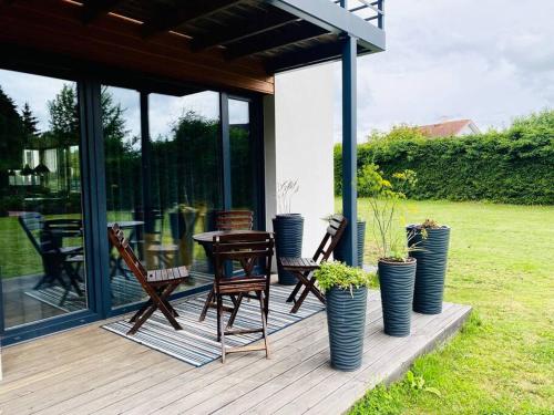 une terrasse avec des chaises, une table et des plantes en pot dans l'établissement A Cozy Retreat - Sauna & Garden - 3BDR, à Pärnamäe