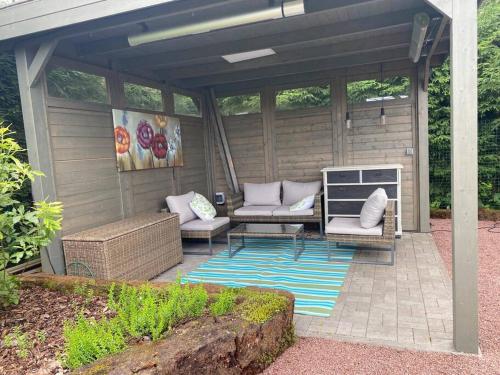 a covered patio with two couches and a rug at A Cozy Retreat - Sauna & Garden - 3BDR in Pärnamäe