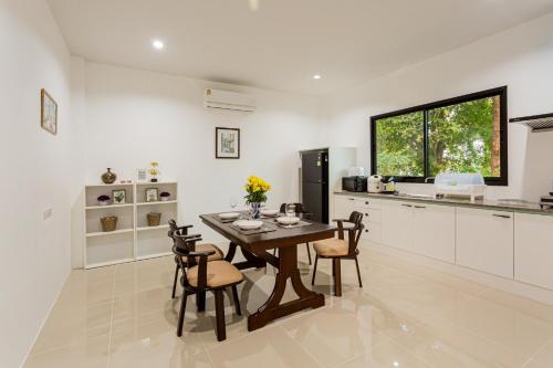 a kitchen and dining room with a table and chairs at Villa loved beach 3 in Ao Nam Mao
