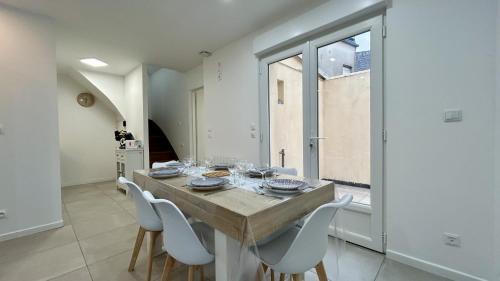 une salle à manger avec une table et des chaises blanches dans l'établissement L'eclaircie, au Crotoy