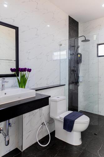 a white bathroom with a toilet and a sink at Villa loved beach 3 in Ao Nam Mao