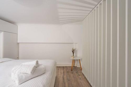 a white bedroom with a bed and a table at Cosy Nest in Athens 4' to Metro Station Petralona in Athens