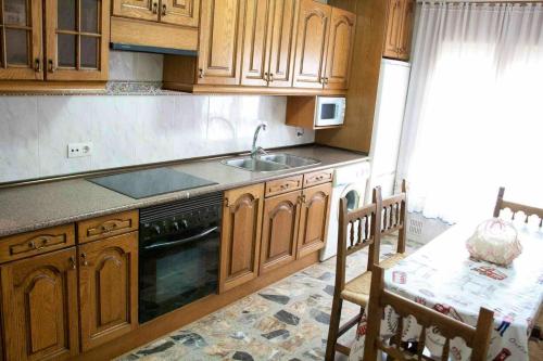 - une cuisine avec des placards en bois, un évier et une table dans l'établissement 4 bedrooms appartement with wifi at Munebrega, à Munébrega