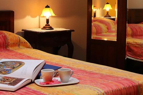 een boek en twee kopjes koffie op een bed bij 2 bedrooms property with shared pool and wifi at Montecarotto in Casa Vici