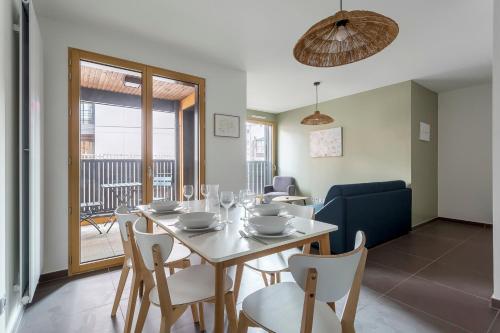une salle à manger avec une table et des chaises blanches dans l'établissement Suite Croix-Rousse : T3 avec patio !, à Lyon