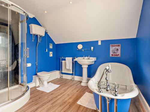 La salle de bains bleue est pourvue d'une baignoire et d'un lavabo. dans l'établissement 3 Bed in Gillingham 53854, à Gillingham