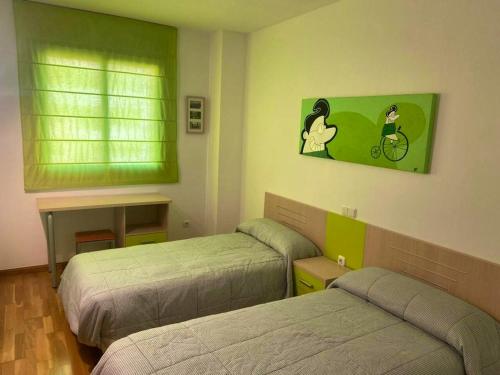 Un dormitorio con dos camas y una pared verde. en Bright Apartment in Alicante, 90 m², Shared Pool, en Alicante