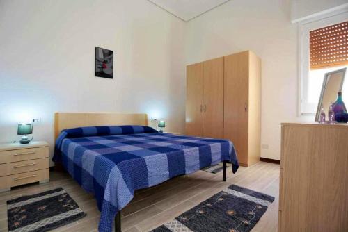 Villaggio Azzurroにある2 bedrooms appartement at Caucana finaiti casuzze finaiti Nord 40 m away from the beach with terrace and wifiのベッドルーム(青と白のベッド1台、キャビネット付)