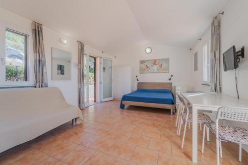 1 dormitorio con 1 cama, mesa y sillas en Appartamenti Norsi, en Capoliveri