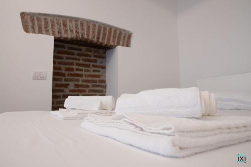 a pile of towels sitting on top of a bed at Loft3 bilo via Morosini centro - Ixihome in Varese
